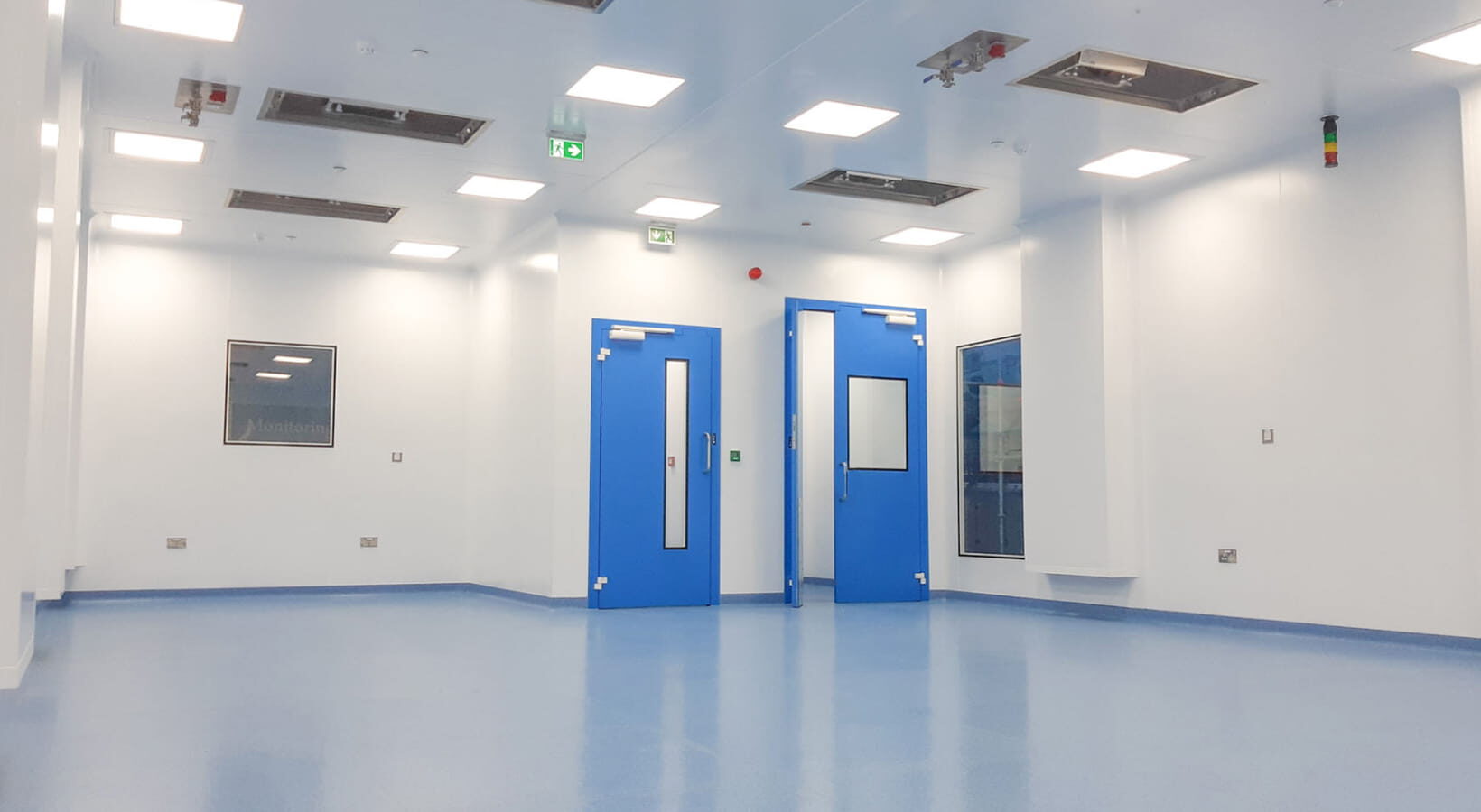 Inside a large POD cleanroom with blue doors.